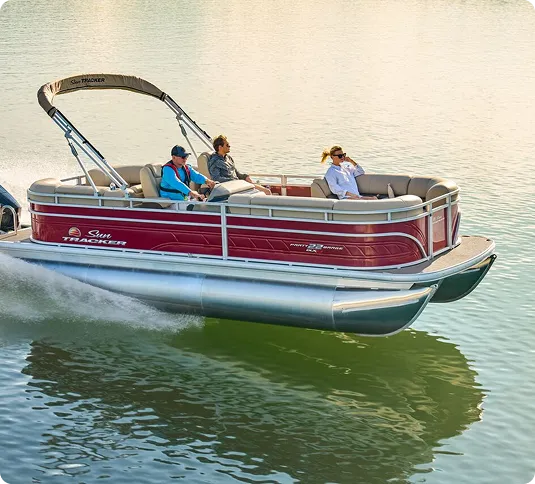 Red boat going full speed with three people over it enjoying life