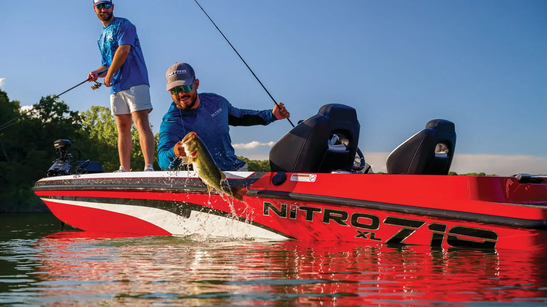 NITRO_compressed A red and white Nitro Z18 bass boat with two fishermen, one of whom is landing a large largemouth bass.